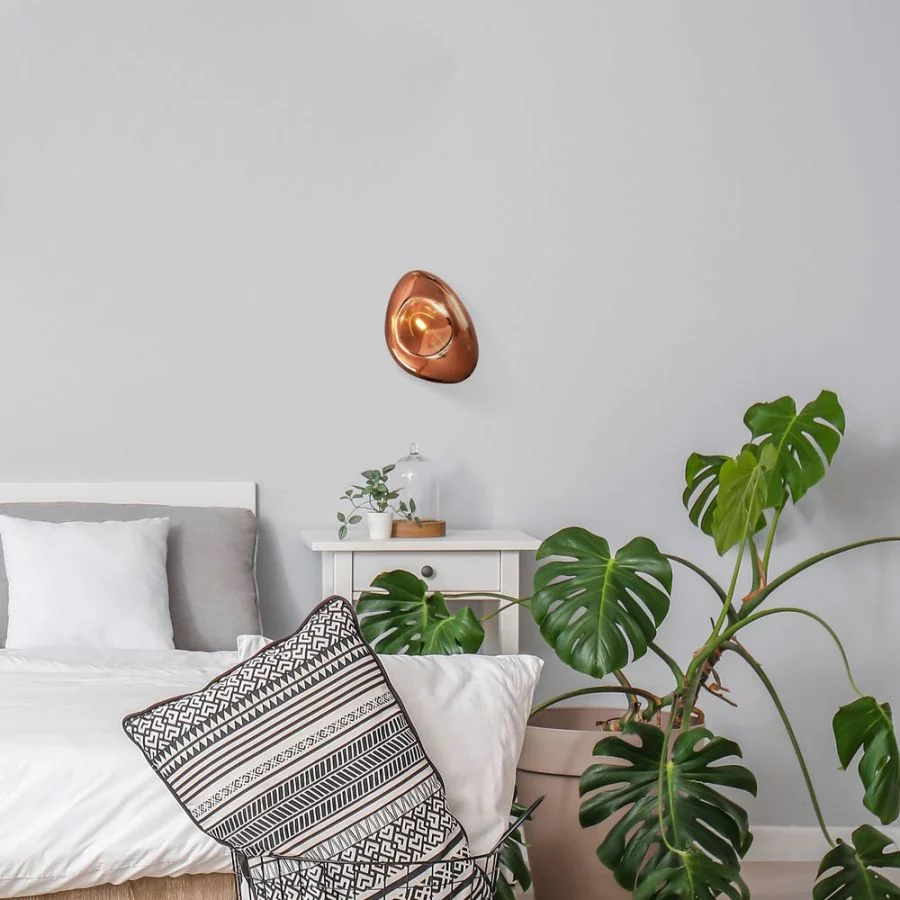 The glass wall light also finds its place in the bedroom